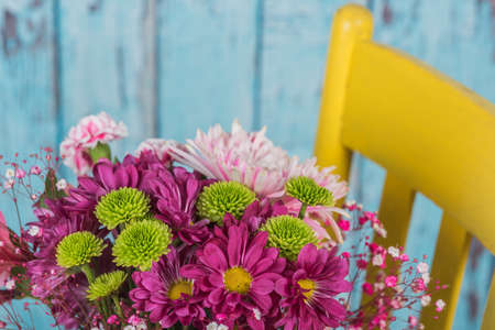 Looking down at a bouquet of flowers in a yellow chair
