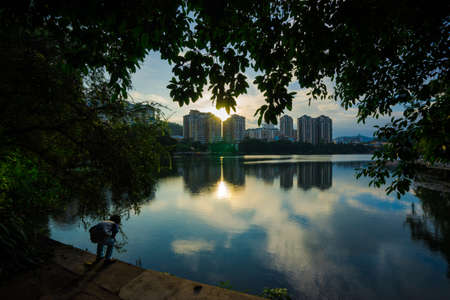 A child looking the fishes by the side of south lake of Huizhou west lake, Chinaのeditorial素材