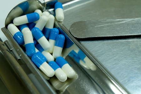 Blue and white capsule on counting tray