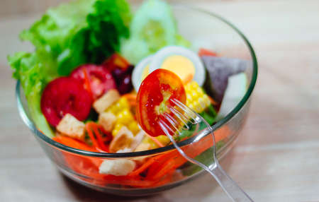 Close up of vegetable salad bowl and fork.Healthy eating, dieting, vegetarian kitchen and cooking.の写真素材