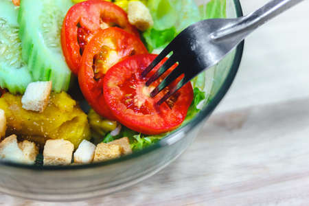 Close up of vegetable salad bowl and fork.Healthy eating, dieting, vegetarian kitchen and cooking.