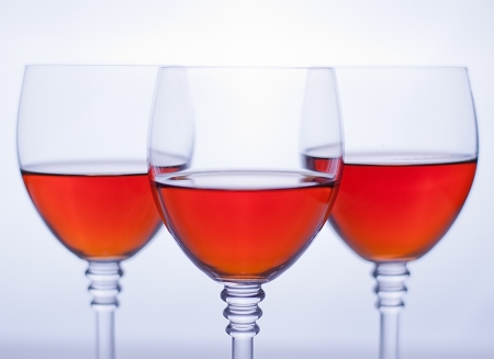Three transparent wineglasses with rose wine  White background