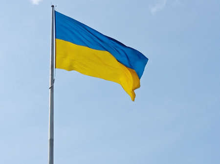 Ukrainian national flag symbol fluttering in blue sky.