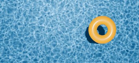 Summer holidays banner. Swimming pool top view. Yellow swimming ring in the empty clear pool.