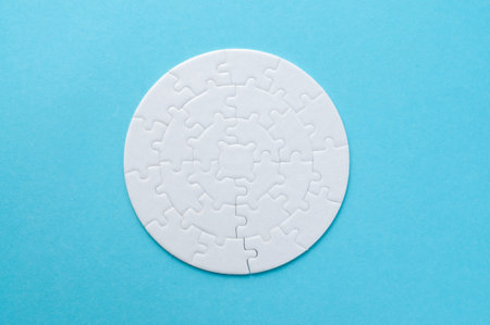 White circle jigsaw puzzle on the blue background. Top view of jigsaw puzzle.の写真素材
