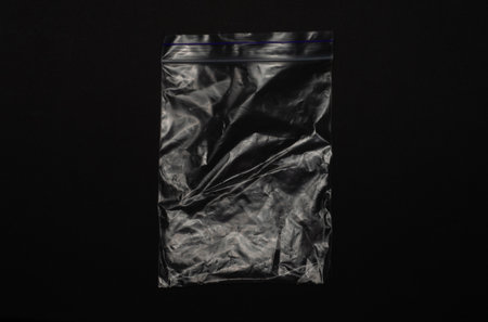 Empty transparent ziplock bag isolated on black background, clear plastic pouch with resealable closure for storage, packaging, organizing, food, travel, and household use.の写真素材