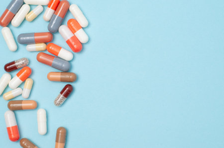 Top view flat lay of capsule pills on white background with copy space. Ideal for healthcare,...