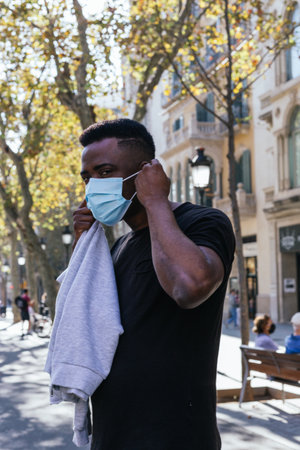 African American looking at the camera just before putting his covid 19 maskの写真素材