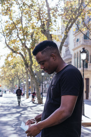 African American looking at the camera just before putting his covid 19 maskの写真素材