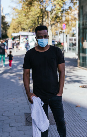African American looking at the camera just before putting his covid 19 maskの写真素材
