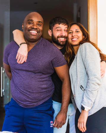 Three interracial friends, where we can see a black men, a spanish men and a latin girl, all posing for a picture. They are all happyの写真素材
