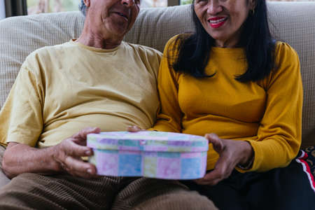 Unrecognizable middle aged couple giving a giftの写真素材