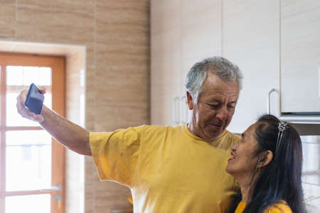 Middle aged marriage taking a selfie starring at each otherの写真素材