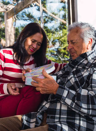 Old interracial couple at Valentines day gibing presentsの写真素材