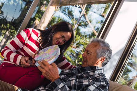 Happy old interracial couple at Valentines day with giftsの写真素材