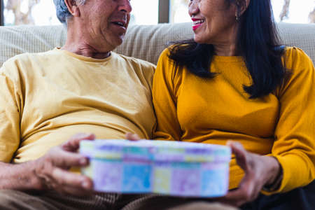 Unrecognizable middle aged couple giving a giftの写真素材
