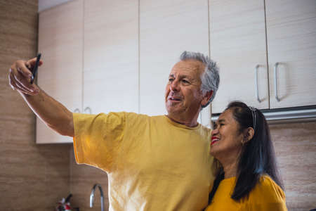 Match yellow middle aged couple taking a selfieの写真素材