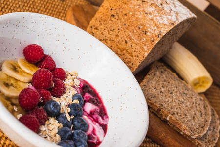 Close up healthy breakfast with a fruit bowl with yoghurtの写真素材