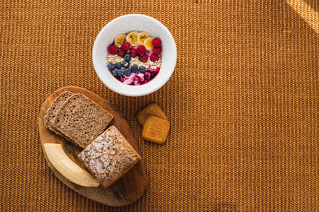 Minimal healthy breakfast with brown bread and a fruit bowlの写真素材
