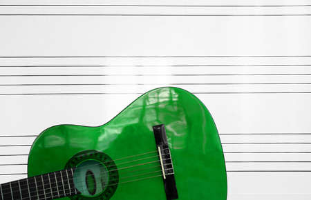 detail of a green Spanish guitar and whiteboard with staveの写真素材