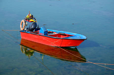 small fishing boat red and blue at seaの写真素材