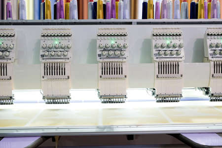 Close-up row of embroidery machine working on factory industry manufacture, industry 4.0
