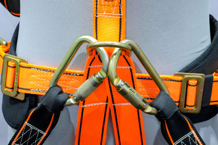 Close-up carabiners locked on safety belt on human model, a safety tools equipment for work at highの写真素材