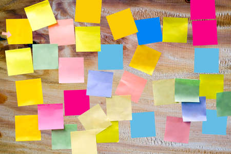Multi-colored empty paper note sticky on wooden board for write a short note for reminder a to do listの写真素材