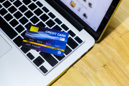 Blue credit card mockup put on keyboard of laptop and blurred web shopping online on display monitor, online shopping and payment via credit card conceptの写真素材