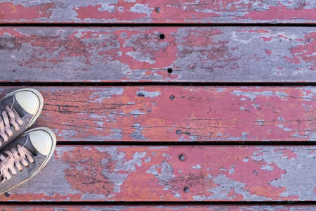 Close-up men's fashion sneakers put on the old wooden bridge and copy space on top-view