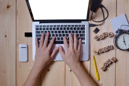 Close-up hands man who typing keyboard on computer laptop portable for work at home with hardware accessories put on wooden desk, stay and work at home concept, top-viewの写真素材