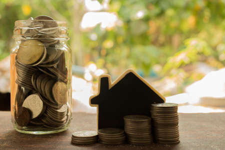 stack of coins with house model ,concept for real estate and finance.の写真素材