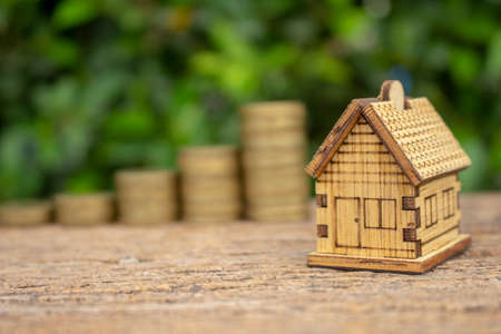 Real estate concept image of house model with stack of coins and space for text.の写真素材