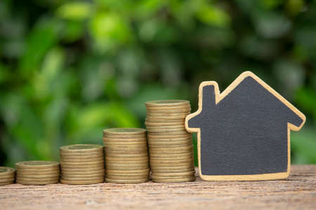 Money saving concept for buy new house image of stack coins with house model on greenの写真素材