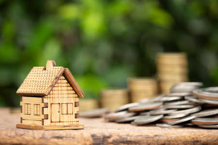 Money saving concept, stack of coins and house model, real estate investment.の写真素材