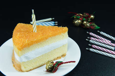 Gold threads cake and bell decoration and candle on texture blackの写真素材