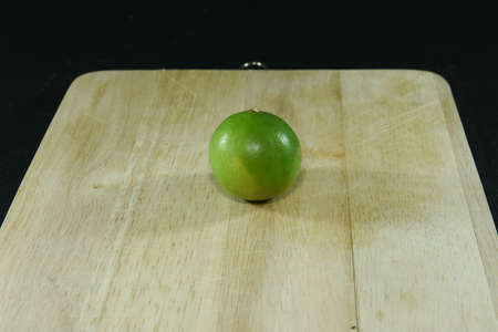 Lemon on wooden block on black background