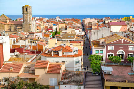 View over the roofs of old town Malgrat de Mar with Mediterranean sea in the background and the Cathedral of the Coast on the left. Malgrat de Mar, Spain - May 03 2016のeditorial素材