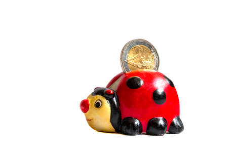 Ladybug savings box or coin bank with two euro coin in it isolated on white backgroundの写真素材