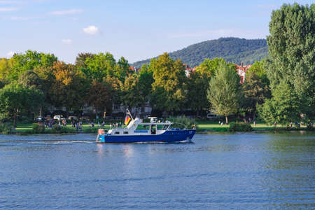 Police patrol boat with a German flag on the Neckar River. Heidelberg, Germany - September 3, 2017