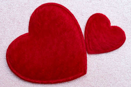 Romance concept - two red fluffy hearts over pink glitter backgroundの写真素材