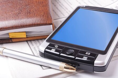 Office still-life (pda, pen, notebook, newspaper. Close up)の写真素材
