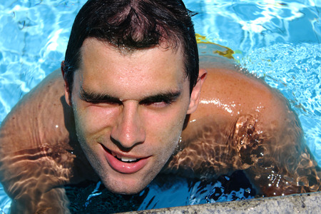 Young man posing in the swimming poolの写真素材