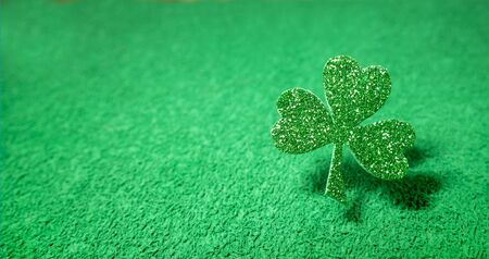 St. Patricks day. Shiny clover leaf on a blurred green background with bokehの写真素材