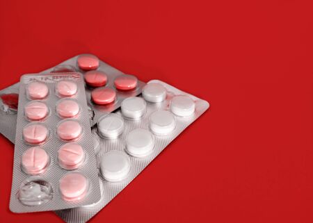 Pharmaceutical preparation. Open blister with tablets on a red background. Medicine