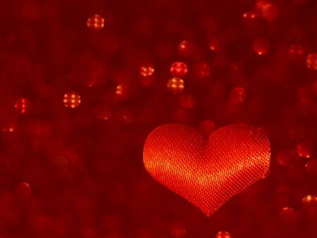 Red heart on a blurry red background with bokeh. defocus. Symbol of love. Valentines day , birthday,...
