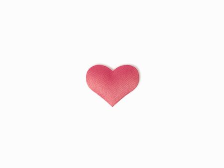 One pink heart made of silk fabric on a white, isolated background.の写真素材