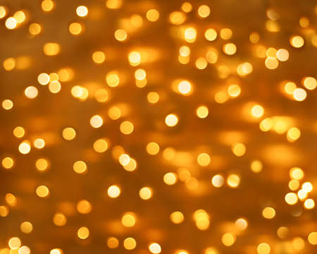 Abstract yellow blurred, shiny background. Bright confetti glitter. Festive Christmas defocused background.の写真素材