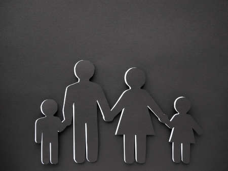 A human symbol made of black paper on a black background. Concept of family. Mom, dad, daughter and...