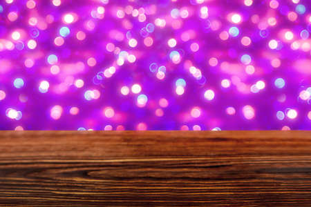 An empty wooden tabletop with a blurry pink bokeh. Background for a festive Christmas decoration.の写真素材